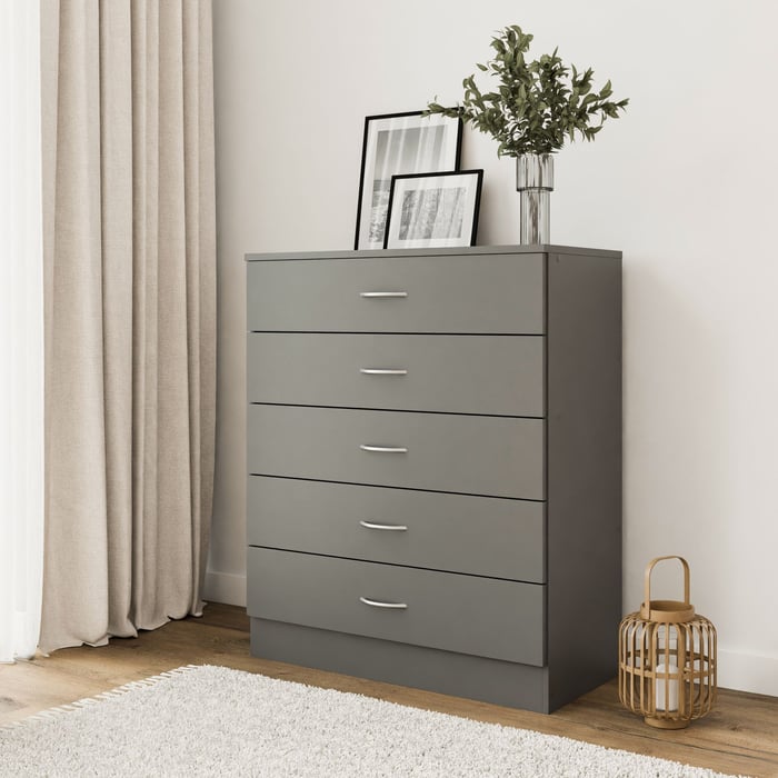 The chest of 5 drawers ESSENTIAL grey in a modern living room.
