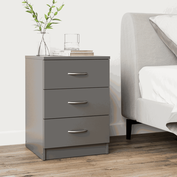 The bedside table ESSENTIAL grey with 3 drawers in a cosy bedroom.