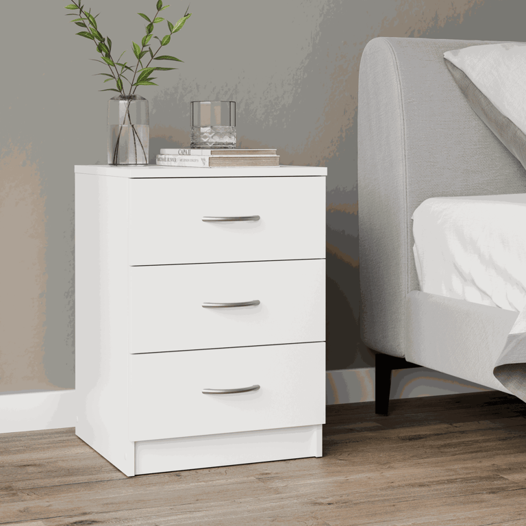The bedside table ESSENTIAL white with 3 drawers in a cosy bedroom.