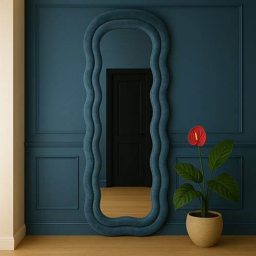 Tall hallway mirror with a wavy blue padded frame against a bold navy wall, paired with a potted plant — playful and stylish inspiration among hallway mirror ideas for eclectic interiors.